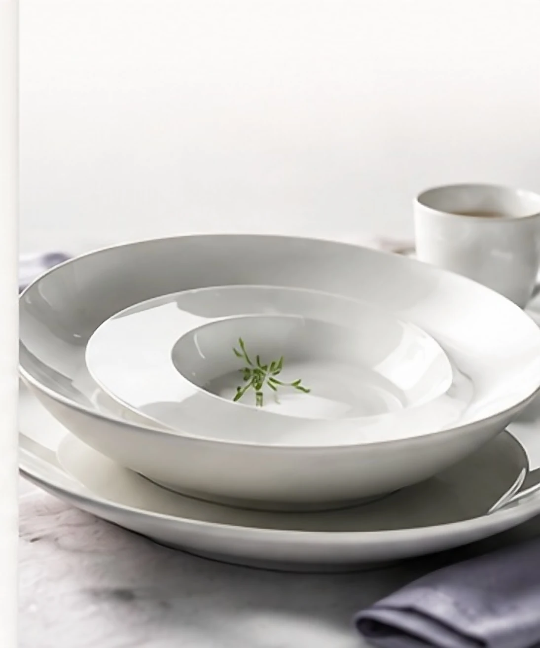 Bright white porcelain plates and a cup stacked for service