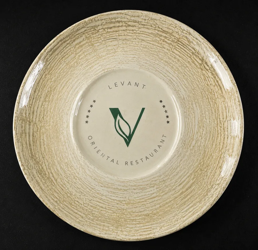 The same plate with a marbled rim glaze and the Levant Oriental Restaurant crest in the well